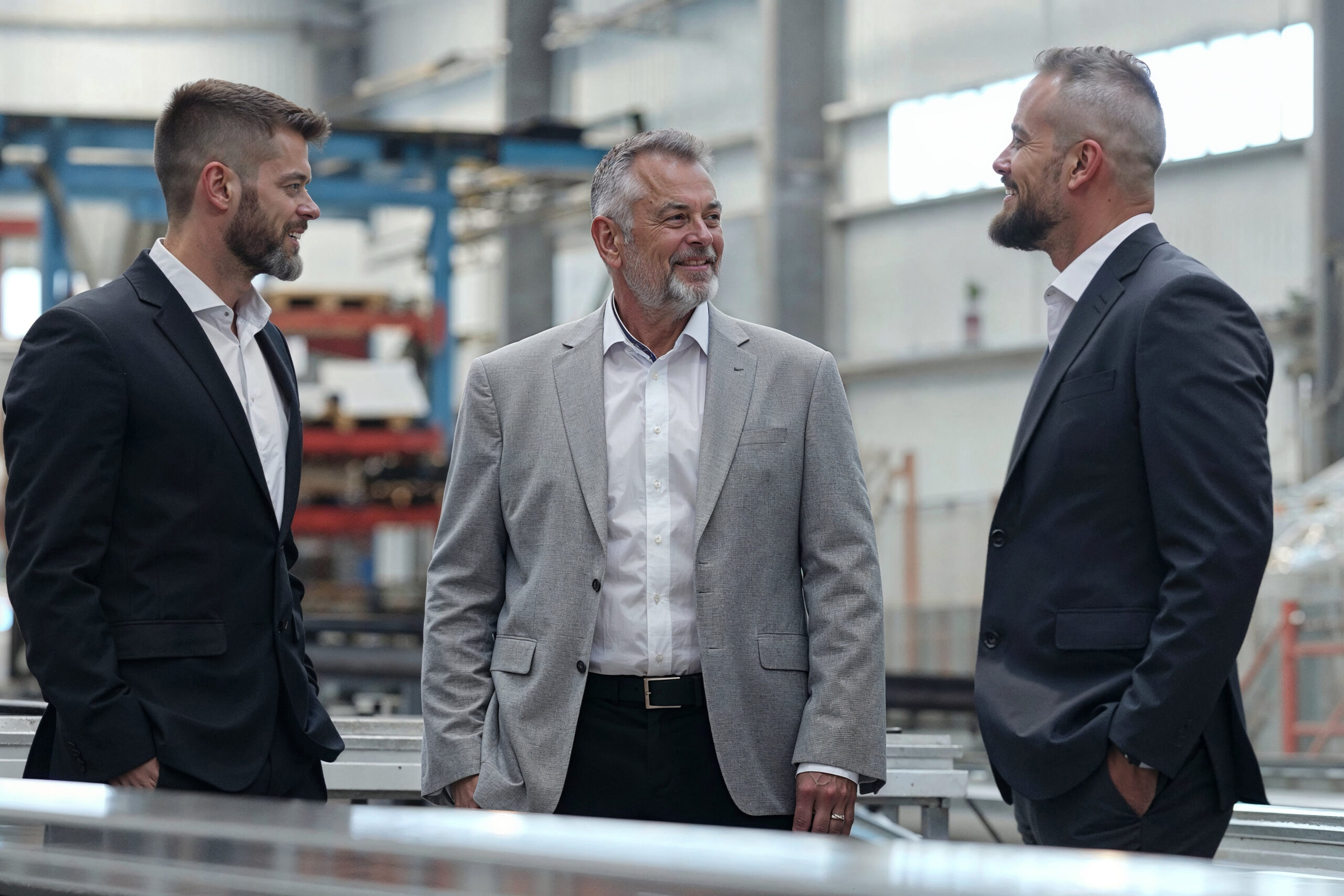 A group of three men stand side by side, possibly discussing business matters related to inheritance and the family business transfer.