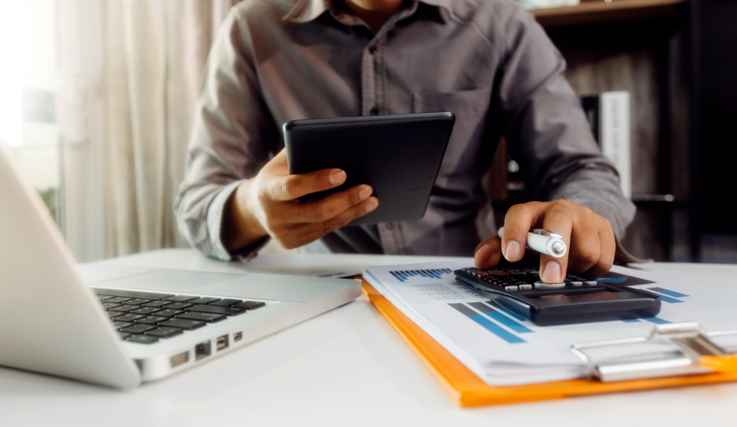 Person sitting at a desk using a calculator