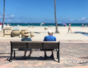 retired couple on bench at beach