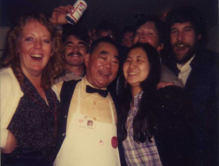 Photo of waiter Edsel Ford Fong with a group of joyous customers in 1982.